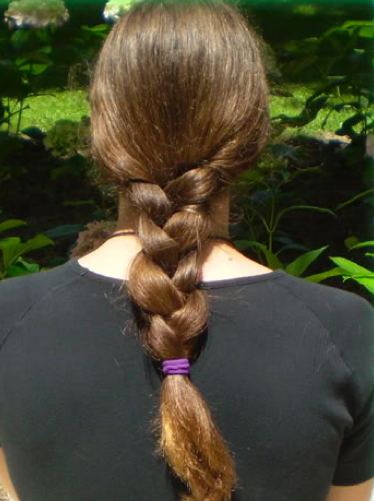 A hair salon photograph of an English braid styled on a young male with very long hair