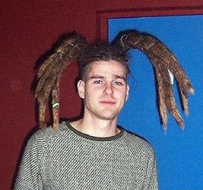 A photo of a young guy with his dreadlocks hairstyle tied into a tarantula undercut haircut