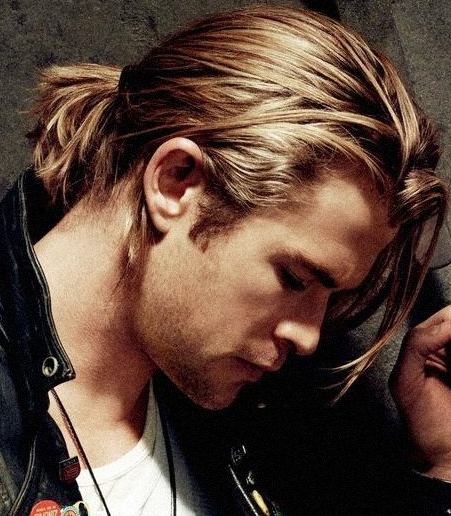 A photograph of Chris Hemsworth with long hair in a ponytail hairstyle