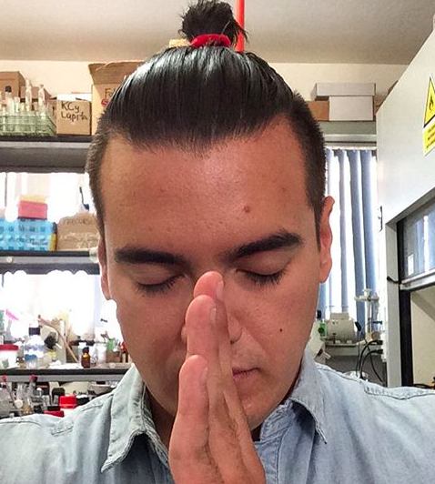 A picture of a businessman with a taper haircut for his man bun hairstyle on the sides and back of his head