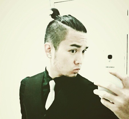 A photograph of a Japanese male with a man bun undercut hairstyle for his long hair