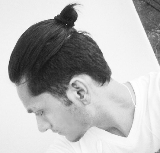 A picture of an Asian male with dark hair and a cool man bun undercut hairstyle