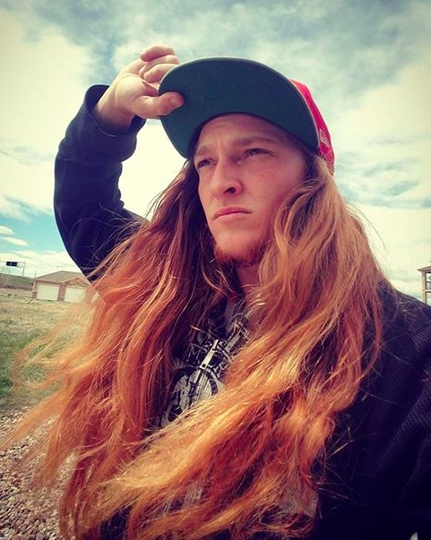 An epic photograph of a handsome Swedish redhead guy with extremely long hair combed as a middle-part hairstyle