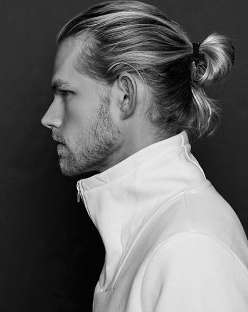A barbershop photograph illustrating a great ponybun hairstyle done on a blonde male with long hair