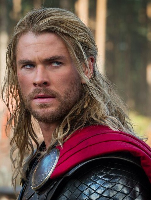 A cool photograph of Chris Hemsworth as Thor with his long wavy hair slicked back into a manly ponytail hairstyle emulating the look of ancient Viking males