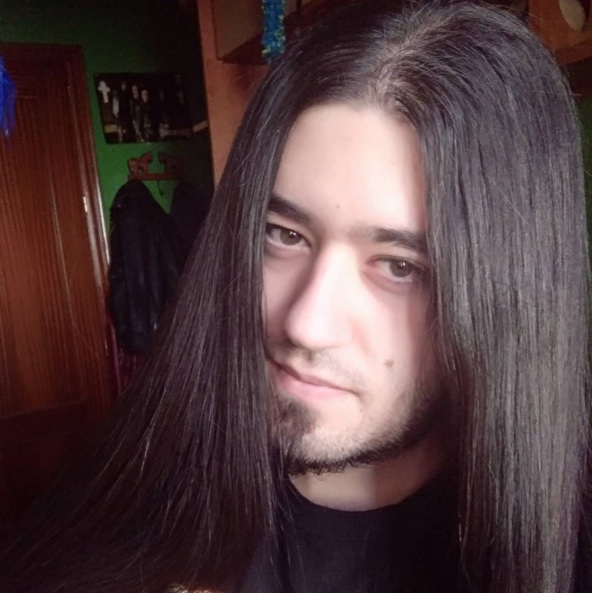 A picture of a Goth male sporting long straight hair after using a flat iron to straighten his long curly mane