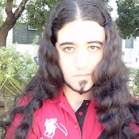 A picture of a Goth male with long coiled-curly hair prior to straightening it by using a flat iron purchased from our barbershop