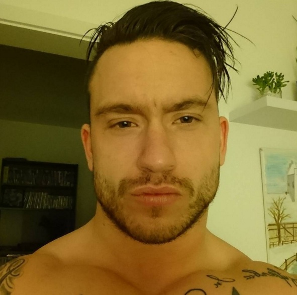 A picture of a muscular male who is growing his hair long starting from a slicked back undercut hairstyle and medium-length haircut