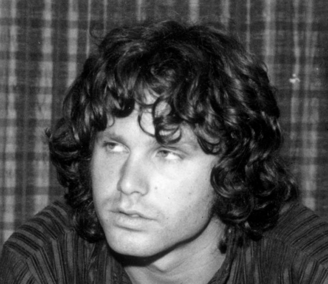 A rare photograph of Jim Morrison with long wavy hair styled with a messy tousled look and achieved by using hair mousse on his curls