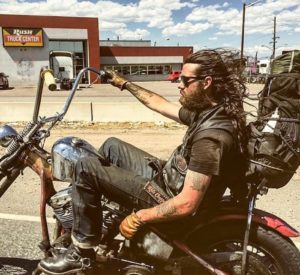 A photo of a long hair male on a Harley Davidson old motorcycle touring the US