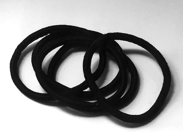 A barbershop photograph of a set of hair elastics with no metal parts that s used by long-haired men to tie their hair in hairstyles like the manbun and the topknot