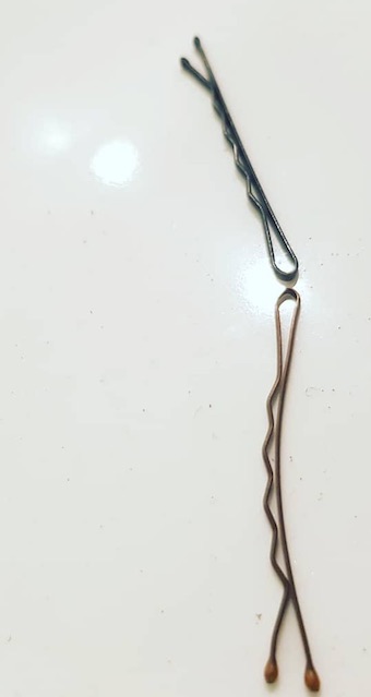 A professional barbershop photograph of a set of bobby pins used to style curly hair for both men and women